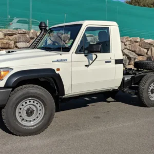 White Toyota LandCruiser 70 Series single cab chassis parked outdoors.